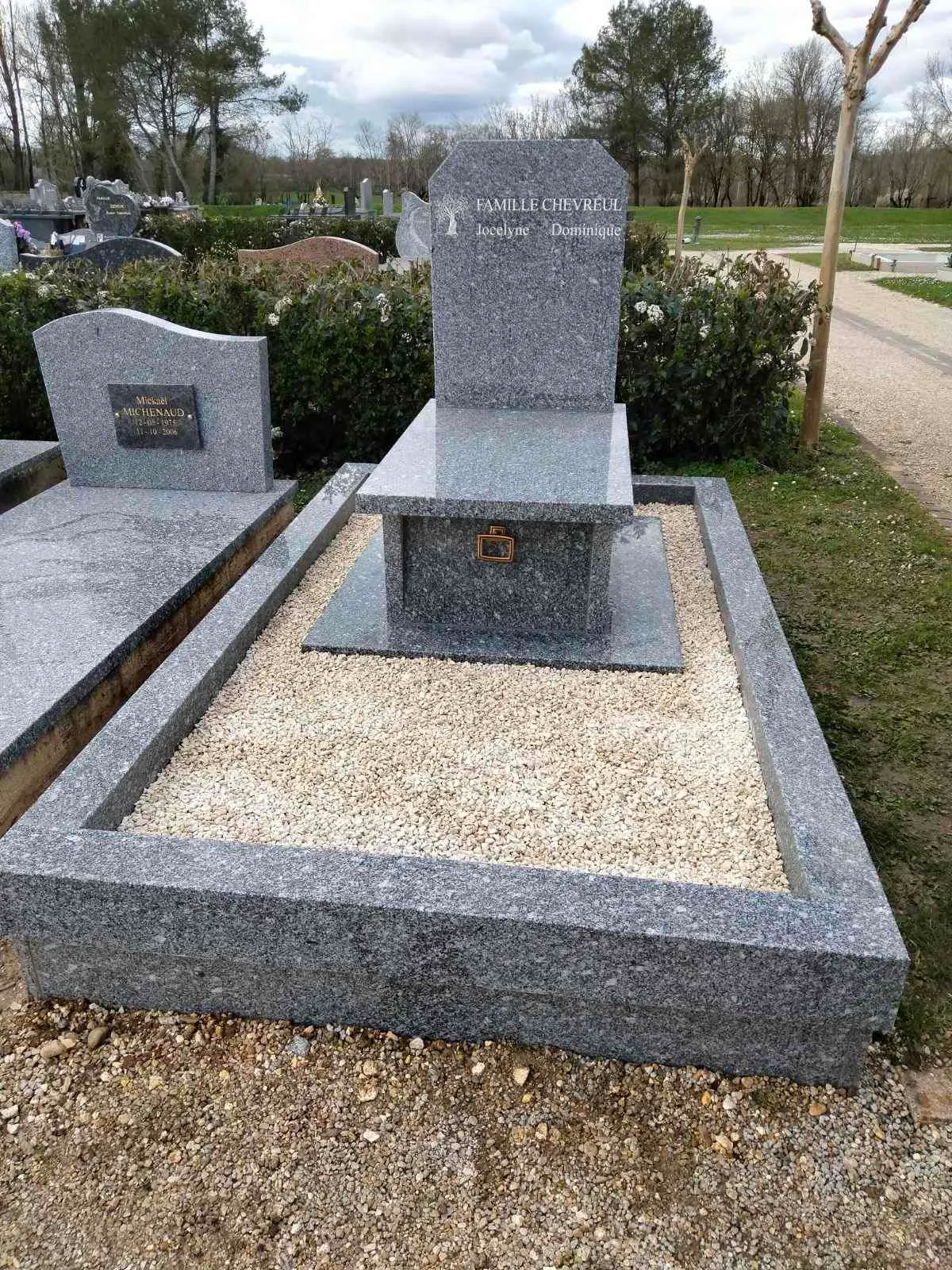 Sépulture personnalisée en granit gris avec soubassement gravier blanc et stèle moderne