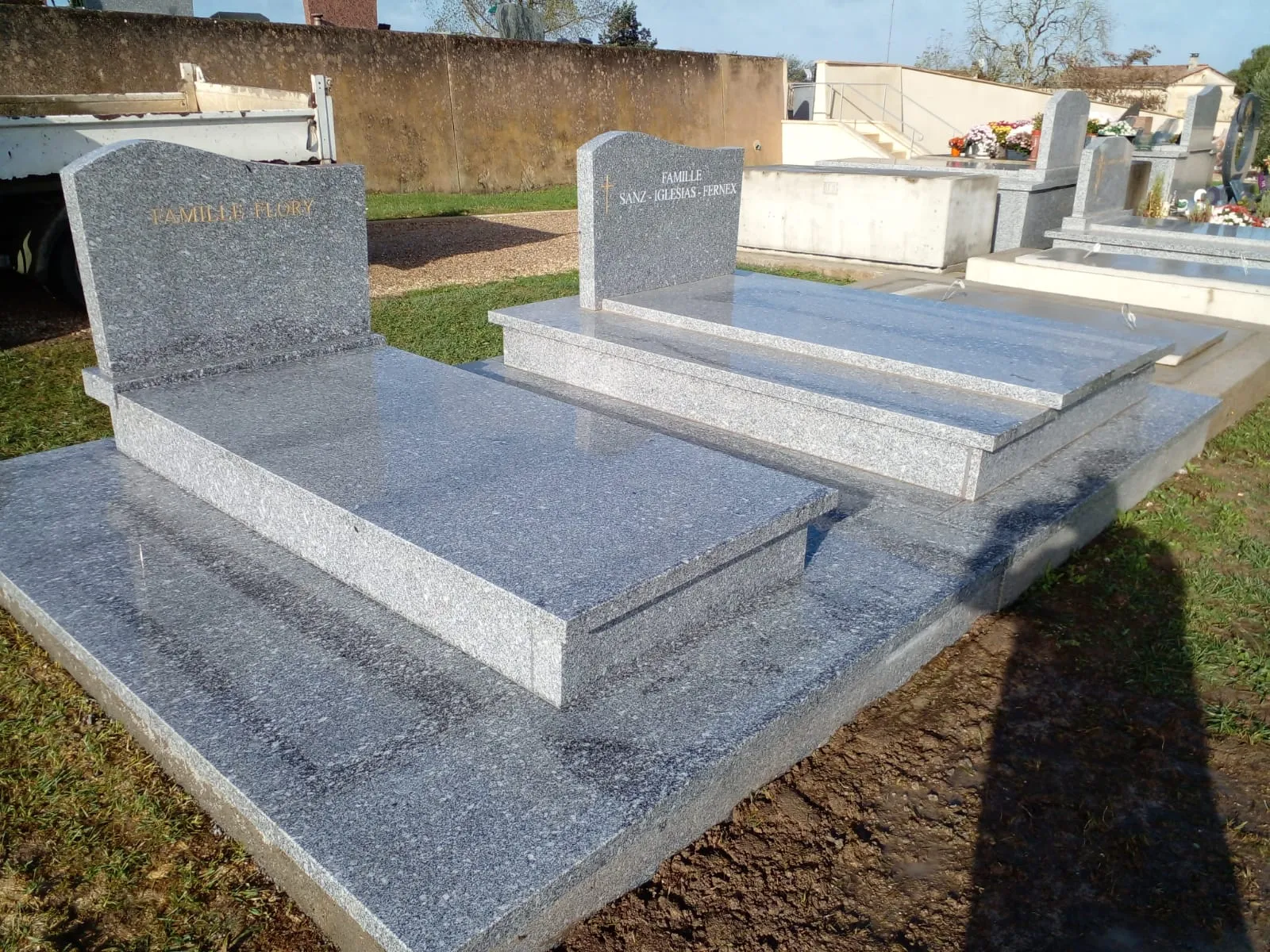 Monuments funéraires jumeaux en granit gris clair par un marbrier en Dordogne