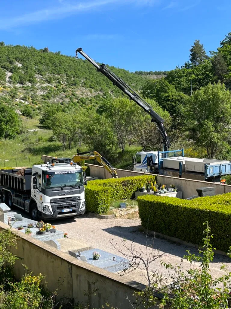 Camion-grue professionnel en intervention pour des travaux de terrassement et marbrerie dans un cimetière