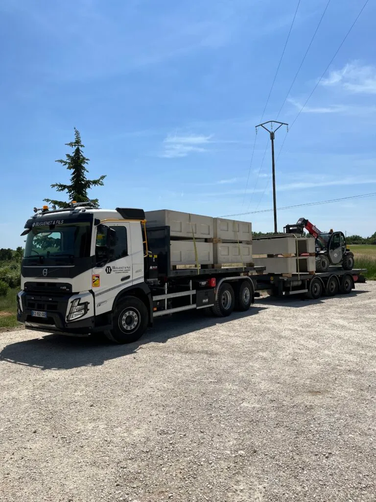 Camion de transport et livraison de caveaux funéraires préfabriqués en béton directement sur site chantiers