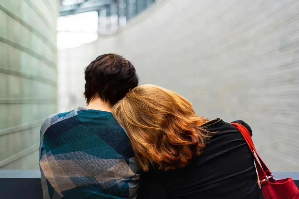 Deux personnes de dos se soutenant mutuellement et partageant leur deuil lors de services aux familles